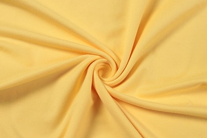 Makro-Detail des gelben Strickstoffs mit weicher Textur und elegantem Spiraldrapierung