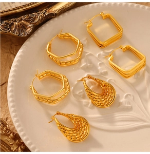 French vintage style earrings in square, hexagonal and teardrop gold designs on white plate