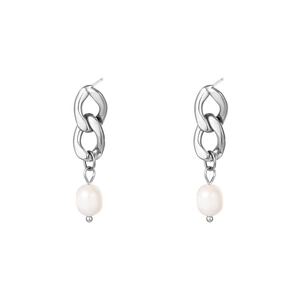 Macro detail of silver pearl drop earrings with polished metal chain links and white pearls