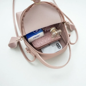 Pink mini PU leather crossbody handbag showing internal storage capacity for women