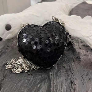 Detail of heart-shaped black sequin evening clutch with silver frame and chain strap