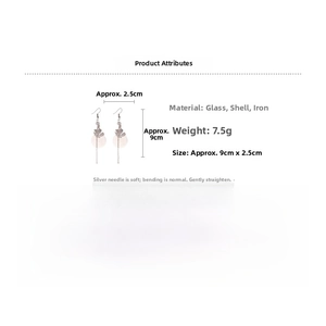 Detail view of flower earrings with shell petals, glass beads, and silver needles
