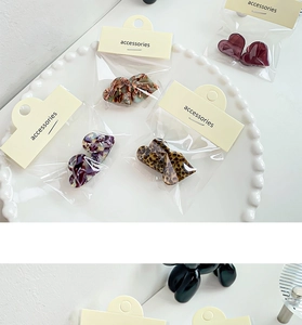Vue détaillée de mini pinces à cheveux en cœur de couleurs variées sur assiette