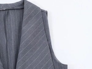 Détail de l'encolure du gilet gris à rayures et de la texture du tissu tissé