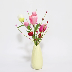 Pink tulips and heart berry picks in a beige ceramic vase for home decoration