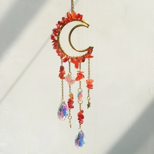 Detail of golden moon suncatcher with red healing crystals and iridescent glass prisms