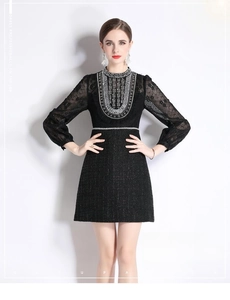 Détail de perles lourdes et manches en dentelle sur robe en tweed noir