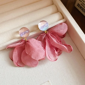 Detail of pink fabric flower earrings with marbled resin studs in a jewelry box