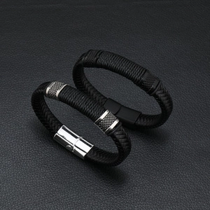 Detailed view of black woven leather bracelets with silver and black magnetic steel clasps