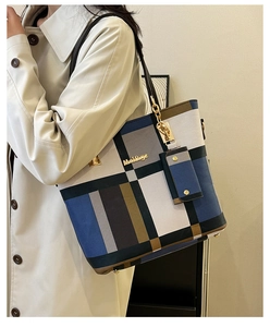 Mannequin portant un grand sac à main à carreaux multicolores avec logo doré et pochette
