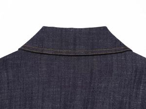 Detailed close-up of dark blue denim fabric texture with orange contrast stitching