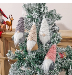 Detail of Christmas gnome hanging ornaments in multiple colors on a snowy pine tree
