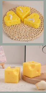 Macro detail of heart and cube cheese shaped scented candles on rustic display pads