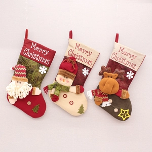 Detailansicht von drei Weihnachtssocken aus Stoff mit Weihnachtsmann, Schneemann und Rentier