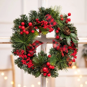 Christmas wreath with red berries and pine cones hanging on a white vintage window