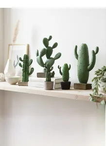 Detail view of resin cactus statues in deep green on wood bases for home decor