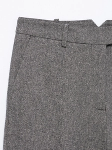 Close-up of gray tweed suit trousers showing premium wool texture and fabric details