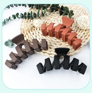 Three-pack of large matte wavy hair claw clips in brown, black, and caramel colors