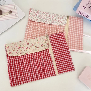 Detail view of floral fabric makeup brush roll organizer with slots and zipper pocket