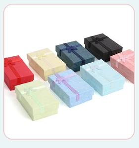 Top view of multi-colored jewelry gift boxes with elegant ribbon bows in organized rows