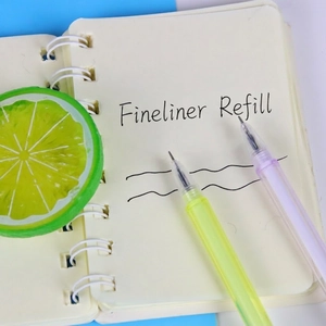 Minimalist crystal heart gel pens in pastel yellow and purple on a coil notebook