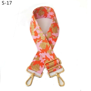 Close-up of pink and orange camo embroidered bag strap with golden metal swivel hooks
