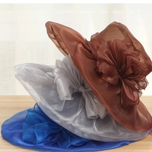Detail of organza sun hats showing oversized floral decorations in brown and blue
