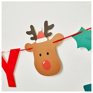 Close-up of Christmas reindeer banner with red letters and green leaves on white wall