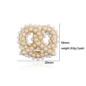 Detailed view of gold pretzel-shaped pearl earrings with 20mm x 18mm size measurements