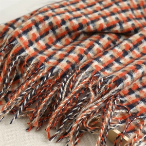 Close-up of vintage British plaid scarf fabric showing thick weave and long fringe details