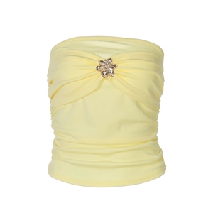 Detalle del top de tubo amarillo con adorno floral dorado y textura de pliegues elásticos