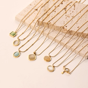 Elegant gold titanium necklace set with cat eye stones and pearls on a stone plate