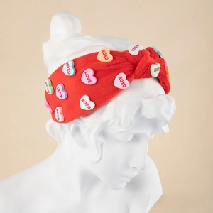 Detail of red plush knot headband with colorful heart patches and XOXO embroidery