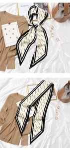 Detail of a beige vintage French silk scarf with black letters used as a stylish hair tie