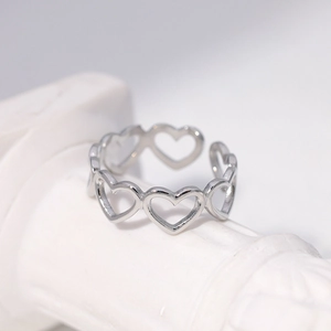 Minimalist silver stainless steel open ring with hollow heart design on a white pedestal