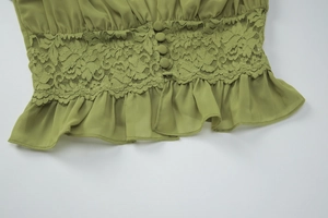 Détails du tissu en mousseline verte avec dentelle délicate et boutons assortis