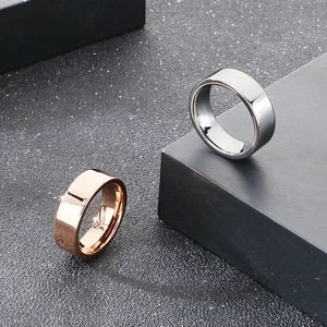 Detail showing polished rose gold and silver 8mm tungsten steel rings on black stand