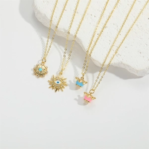 Golden necklaces featuring sun, evil eye, and crown pendants on white stone blocks
