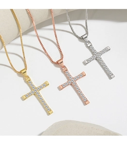 Detailed macro view of cross pendants in gold, rose gold, and silver with zircons