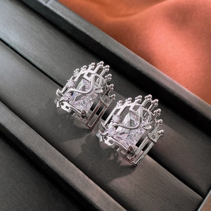 Close-up of silver earrings featuring rectangular zircon stones and hollow floral patterns