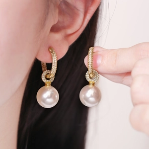 Boucles d'oreilles perles dorées avec zircons sur mannequin pour un style luxueux