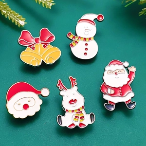 Flat lay of Christmas enamel pins featuring Santa, snowman, bells and reindeer