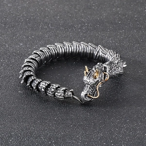 Close-up of silver dragon bracelet with golden horns and detailed metallic scales