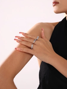 Detail view of multi-color gemstone and white zircon rings worn on a hand