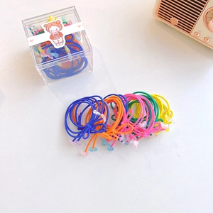 Detail of colorful elastic hair bands with heart charms in a square storage box