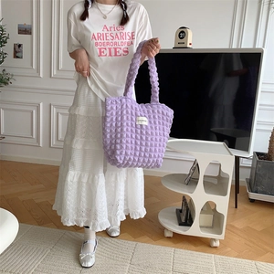 Lifestyle shot of a purple puffy tote bag with unique bubble fabric texture for women