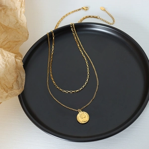 Double layered gold coin necklace with Queen Elizabeth II portrait on matte black plate