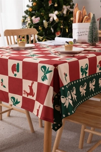 Close-up of festive Christmas tablecloth with red deer, holiday motifs and green border