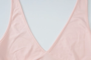 Close-up of pink V-neckline with delicate lettuce trim and high-quality stitching detail
