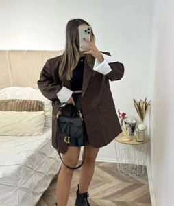 Close-up of brown striped oversized blazer with dramatic white wide folded cuffs